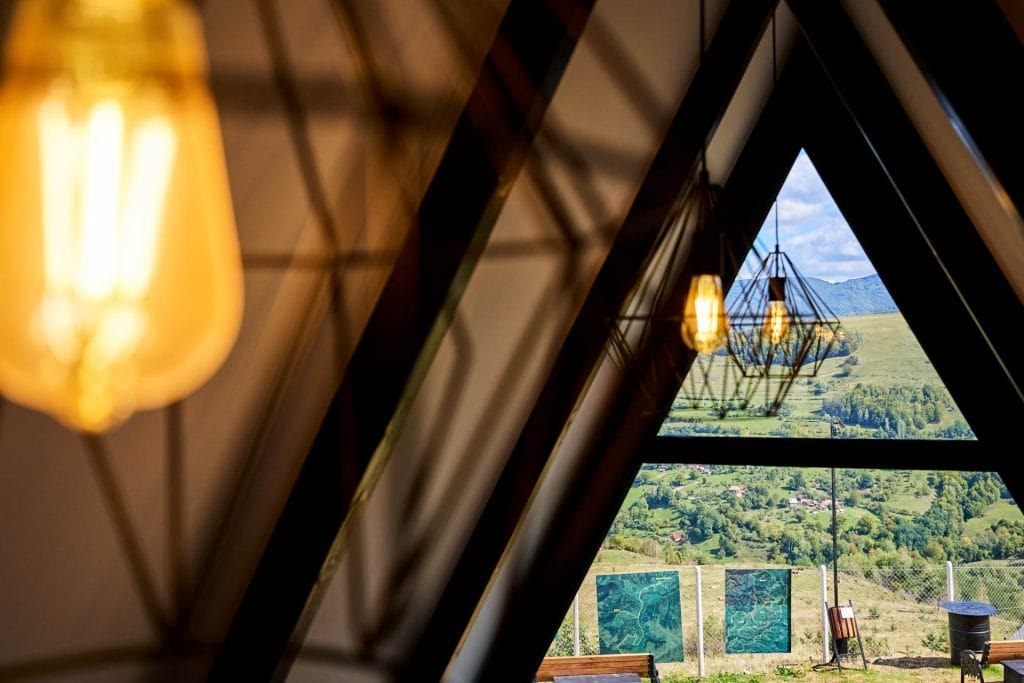 Inside the A-frame — the glass gable framing the Apuseni valley
